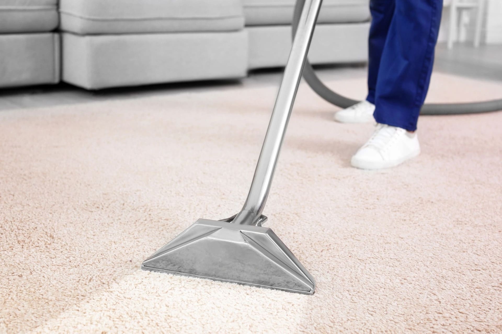 A carpet cleaning wand on a beige carpet