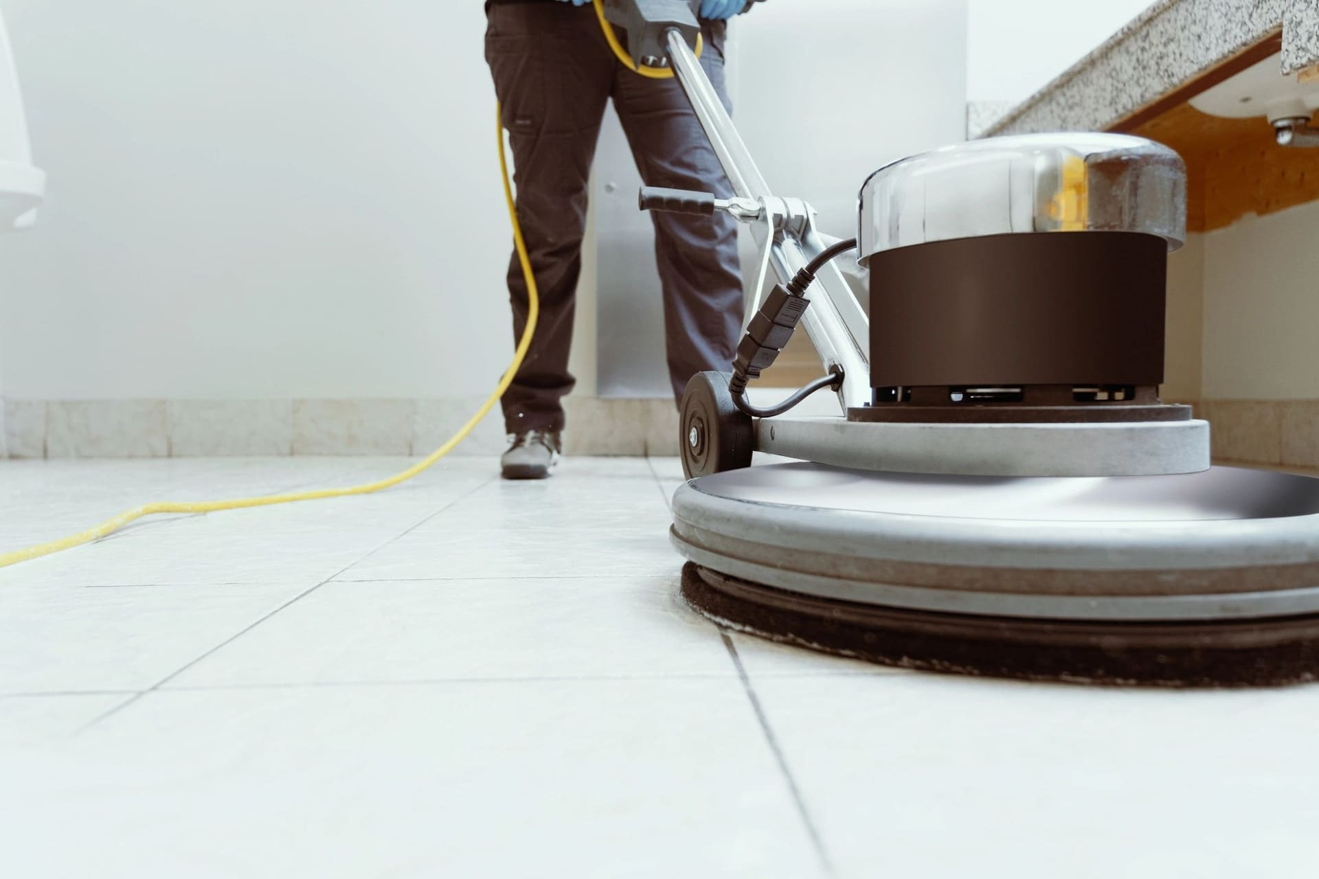 A floor buffing machine on a white tile floor