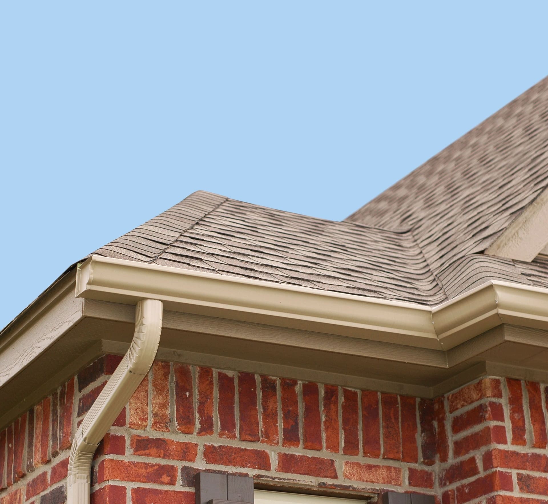 A seamless gutter and downspout along a roofline