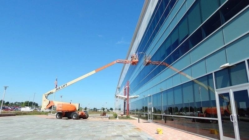 Commercial window cleaning by ASJ from powered lifts on a glass facade